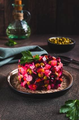 Traditioneller Rote-Bete-Salat mit gekochtem Gemüse und Essiggurken auf einem Teller auf dem Tisch Vertikalansicht Traditional beetroot salad with boiled vegetables and pickles on a plate on the table vertical view Copyright: xZoonar.com ElenaxRuix 22776769