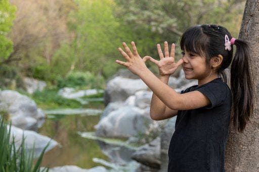 A little girl teasing in a beautiful holiday park. 22004092 ,model released, Symbolfoto RECORD DATE NOT STATED