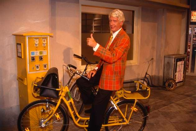 DIE POST GEHT AB Die Post geht ab, RTL Spielshow, 1993, Gastgeber und Moderator Rudi Carell präsentiert Kandidaten und Spiele am laufenden Band, hier auf einem gelben Postrad, Deutschland Copyright: kpa kpa_55052012 EDITORIAL USE ONLY