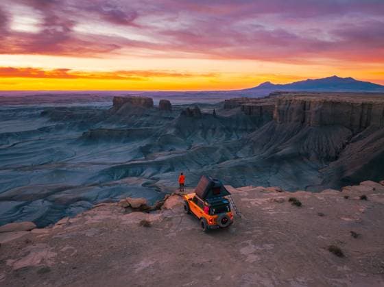 Yellow Truck Rooftop Tent Camping on a Cliff with a Lone Traveler Hanksville, Utah, United States CR_EVVA250214-1639823-01 ,model released, Symbolfoto