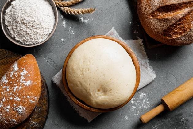 Schüssel mit frischem Teig, Backkonzept Bowl of fresh yeast dough with flour, rolling pin and fresh sourdough bread. Baking and kneading concept background. Copyright: xZoonar.com OksanaxBratanovax 22882296