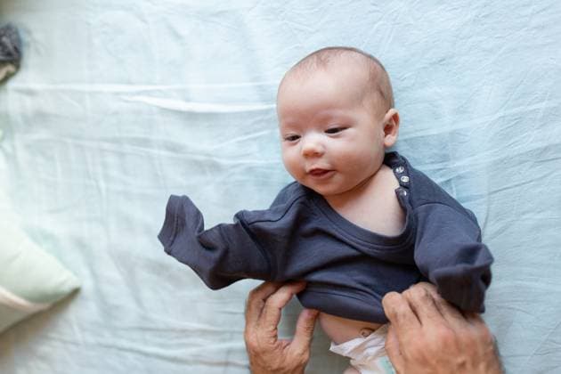 Creative Highlights Symbolfotos MR_GermanGomez_Baby.jpg, MR_HectorGomez_Baby.jpg From above of crop unrecognizable father changing clothes of adorable baby lying on bed in daylight Model Released LeoPastor_ID18055_543177_005 Copyright: xLeoxPastorx