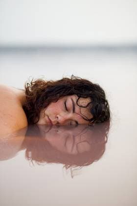 Creative Highlights Symbolfotos MR_MariaTeresaLopez_PinkLake.jpg Tranquil female with closed eyes lying with half of face in water of pink pond in summer Model Released LeoPastor_ID18064_543483_012 Copyright: xLeoxPastorx