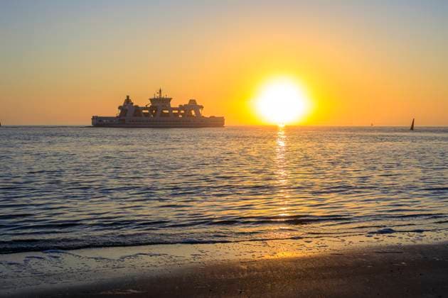 Fährschiff und Sonnenuntergang an der Westküste von Norderney, Niedersachsen, Deutschland *** Ferryboat and sunset on the west coast of Norderney, Lower Saxony, Germany
