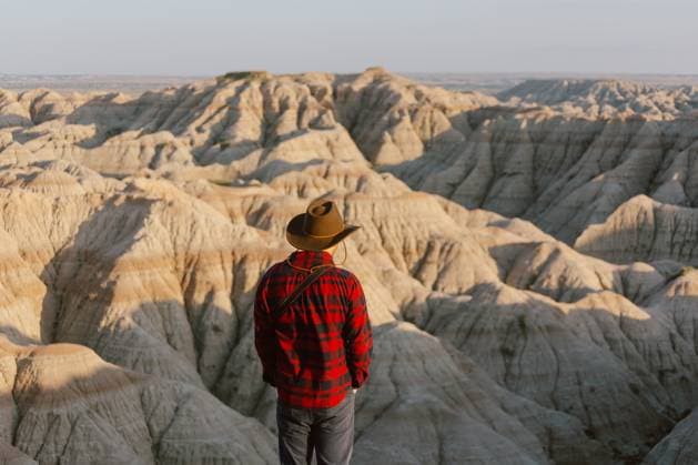 Creative Highlights Symbolfotos Traveler in cowboy hat admires the rugged Badlands landscape. Scenic, South Dakota, United States CR_YFNE250218-1475401-01 ,model released, Symbolfoto