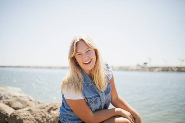 Creative Highlights Symbolfotos Young Woman sitting on a rock by the ocean Long Beach, California, United States R_KFPD250217-1648448-01 ,model released, Symbolfoto