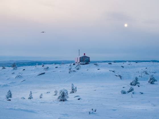 Einsame rote Bungalowauf einem verschneiten frostigen Hügel unter dunklen Abendhimmel mit einem Vollmond. Minimalistischer Hintergrund mit einer einsamen roten Hütte im Winter. Lonely red bungalowon a snowy frosty hill under dark evening sky with a full moon. Minimalistic background with of lonely red cabin in winter. Copyright: xZoonar.com StanislavxSablinx 22907188