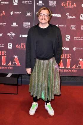 Nilz Bokelberg, eigentlich Nils Bokelberg der Moderator traegt einen Rock zu Gast auf dem roten Teppich bei der Koelner Aids Gala - Die Gala im Musical Dome am 02.Dezember 2024 in Koeln NRW Deutschland