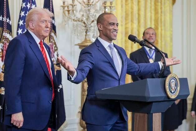White House Opportunity and Revitalization Council Executive Director Scott Turner (C) speaks while standing with US President Donald J. Trump (L) and golfer Tiger Woods (R) during a reception honoring Black History Month in the East Room of the White House in Washington, DC, on February 20, 2025.  WAX20250220865 SHAWNxTHEW