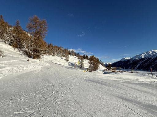 A scenic winter landscape of a snow-covered ski slope with clear blue skies and surrounding mountains in Livigno, Italy. 28040378 RECORD DATE NOT STATED