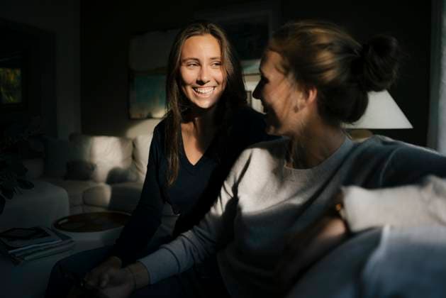 Creative Highlights Symbolfotos Two happy teenage girls with cell phone sitting on couch at home model released, Symbolfoto property released, JOSF02942