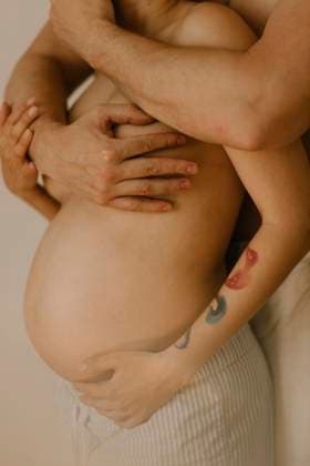 Creative Highlights Symbolfotos Husband embracing naked pregnant woman at home model released, Symbolfoto property released, VIVF01486
