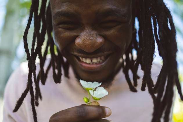 Creative Highlights Symbolfotos Cheerful young man with flowers in park model released, Symbolfoto, ALZF00987