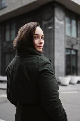 Creative Highlights Symbolfotos Woman wearing warm coat looking over shoulder at street model released, Symbolfoto, EYAF03310