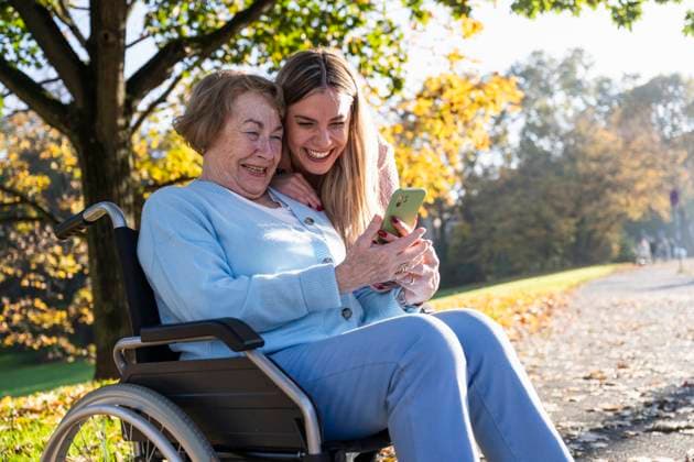 Happy grandmother and granddaughter spending leisure time using smart phone at street model released, Symbolfoto, UUF34015
