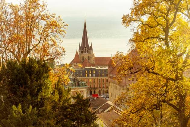 Cityscape of Lausanne with cathedral spire and autumn trees in warm colors, Lausanne Vaud Switzerland westend TAMF04714