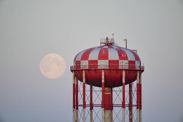 Large moon rising next to checkered water tower Keflavík, Iceland R_OSBJ250223-1656776-01