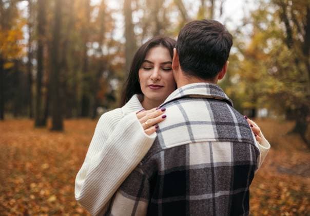 A couple embraces in an autumn forest surrounded by vibrant leaves. The woman closes her eyes with a serene smile, capturing love and tranquility in nature™s beauty. Model Released VolhaShestak_ID26497_764585_005 Copyright: xVolhaxShestakx