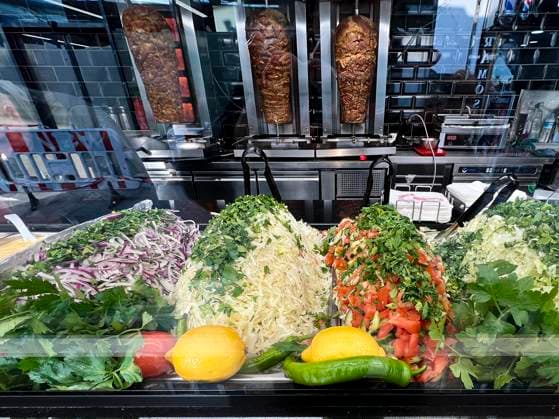 IMAGO Creative, Food, Fast Food, Döner Serviert wird der Doener als Hauptgericht mit Beilagen Verschidene Sorten Gruener Kraut Zwiebeln und Tomaten Salat. Ein knapperes Angebot an Rindfleisch schlaegt auf Deutschlands Fast-Food-Branche durch Doener sind sehr viel teurer geworden-- Der Doener Kebab drehendes Grillfleisch ist ein Gericht der tuerkischen Küche. Er besteht aus mit Marinade gewürzten Fleischscheiben, die schichtweise auf einen senkrecht stehenden Drehspieß gesteckt und seitlich gegrillt werden. Von diesem werden nach und nach die aeußeren, gebraeunten Schichten duenn abgeschnitten. Hamburg Deutschland *** The Doener is served as a main course with side dishes Various types of green cabbage Onions and tomatoes Salad A scarcer supply of beef is hitting Germanys fas