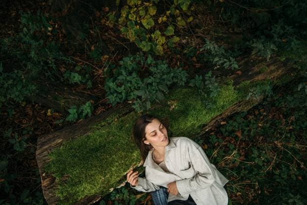 Creative Highlights Symbolfotos Young woman lies on the ground in the forest Enschede, Overijssel, Netherlands CR_MAPU250219-1644569-01 ,model released, Symbolfoto