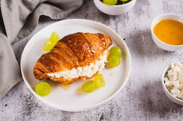 Croissant with ricotta, grapes and honey on a plate on a table Croissant with ricotta, grapes and honey on a plate on a table Copyright: xZoonar.com ElenaxRuix 22966734