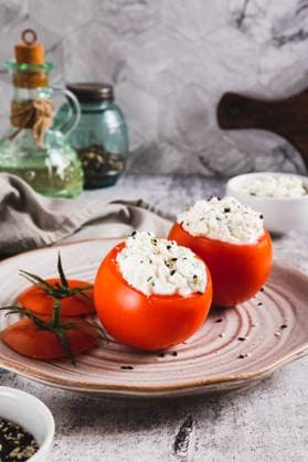 Fresh tomatoes filled with cottage cheese and herbs on a plate on the table vertical view Fresh tomatoes filled with cottage cheese and herbs on a plate on the table vertical view Copyright: xZoonar.com ElenaxRuix 22966985