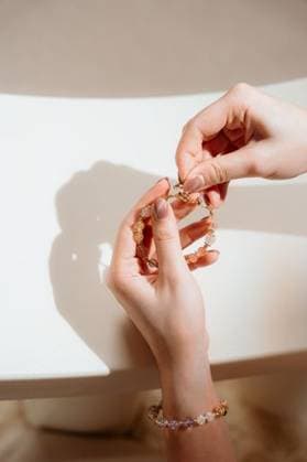 Creative Highlights Symbolfotos Close-up of hands holding a beaded bracelet with a soft shadow, showcasing delicate jewelry craftsmanship. 29437125 RECORD DATE NOT STATED