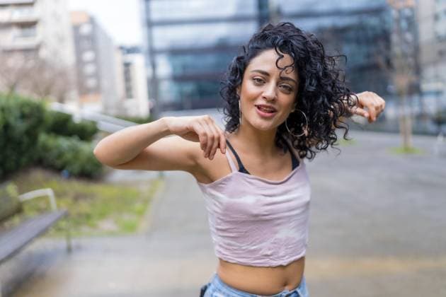 Lockenköpfige Frau, die draußen tanzt und eine moderne Tanznummer in einer städtischen Umgebung aufführt Curly haired woman dancing outside, performing a modern dance routine in an urban environment Copyright: imageBROKER UnaixHuizi ibxuhu12803048.jpg ,model released, Symbolfoto ,property released