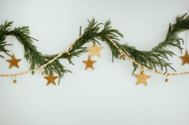 Festive greenery garland with wooden beads and star ornaments on white Chicago, Illinois, United States R_AKAO250212-1627666-01
