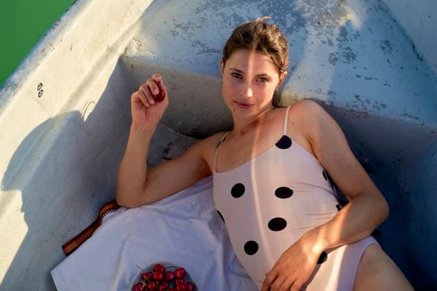 Creative Highlights Symbolfotos Woman in polka dot swimsuit lounging in boat with cherries and sunlight casting shadows. Brandenburg, Germany Brandenburg Germany bola07156 Copyright: xConnectxImagesx ,model released