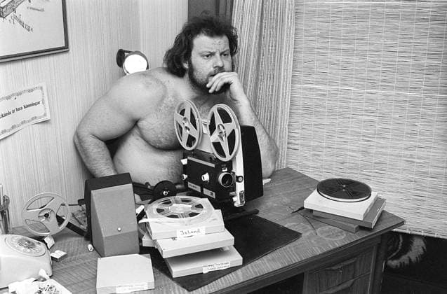Filmprojektor im Jahr 19702. Ricky Bruch (1946 2011) Schwedischer Leichtathlet. Er nahm an Wettkämpfen im Diskuswerfen und Kugelstoßen teil. Er blickt auf die Leinwand, auf der der Film gezeigt wird. Der Film wurde normalerweise auf einer weißen Leinwand gezeigt. Die vordere Rolle auf dem Projektor enthält den fertigen Film, die hintere Rolle ist der Film, der aufgerollt wird, wenn er angesehen wird. Wenn der Film zu Ende ist, wird die hintere Rolle, die den Film enthält, wieder auf die ursprüngliche Rolle zurückgerollt. Schweden 1975 Film projector in the 19702. Ricky Bruch (1946-2011) Swedish track and field athlete. He competed in the discus and shot put sports. He has his eyes on the screen where the film is shown. The film was usua Copyright: imageBROKER Sjoberg ibljsj12886055.jpg
