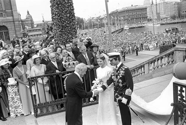 Hochzeit von Carl XVI. Gustaf und Silvia Sommerlath. Carl XVI. Gustaf, König von Schweden. Geboren am 30. April 1946. Die Hochzeit am 19. Juni 1976 in Stockholm. Königin Silvia in ihrem Hochzeitskleid mit König Carl XVI. Gustaf auf der Treppe des königlichen Schlosses in Stockholm mit einer jubelnden Menschenmenge im Hintergrund Wedding of Carl XVI Gustaf and Silvia Sommerlath. Carl XVI Gustaf, King of Sweden. Born 30 april 1946. The wedding 19 june 1976 in Stockholm. Queen Silvia in her wedding dress with king Carl XVI Gustaf on the stairway to the royal castle in Stockholm with crowds of people in the background cheering Copyright: imageBROKER Sjoberg ibljsj12891624.jpg
