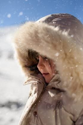 Creative Highlights Symbolfotos A young child in a fur-lined coat enjoys a snowy day at Sierra Nevada Ski Resort, Granada. The bright sky and falling snowflakes create a magical winter scene. Model Released MagdalenaCarli_ID26941_777275_003 Copyright: xMagdalenaxCarlix RECORD DATE NOT STATED