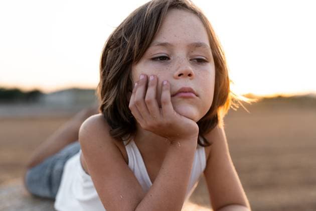 Creative Highlights Symbolfotos A portrait of a child lying on the bale of straw with a thoughtful expression, set against a warm, golden sunset. The serene outdoor setting adds a peaceful, contemplative mood. Model Released MagdalenaCarli_ID27200_782260_001 Copyright: xMagdalenaxCarlix