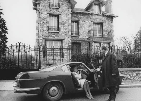 Volvo P1800. Ein von Volvo Cars hergestellter Sportwagen, der von 1961 bis 1973 produziert wurde. Das Design stammt von dem schwedischen Designer Pelle Pettersson. Der Wagen wurde 1961 auf dem Genfer Autosalon vorgestellt. Der P1800 wurde weithin bekannt, als er von dem späteren James Bond Darsteller Roger Moore als Simon Templar in der Fernsehserie The Saint gefahren wurde. Das Bild zeigt die schwedische Schauspielerin Gunnel Lindblom mit ihrem Mann vor ihrer Villa in Frankreich mit ihrem Volvo P1800. 1965 Volvo P1800. A sports car manufactured by Volvo Cars wtih start 1961 and ending 1973. Styling was by swedish designer Pelle Pettersson. The car was indroduced at the Geneva Motor Show in 1961. The P1800 became widely known when drive Copyright: imageBROKER Sjoberg ibljsj12900019.jpg