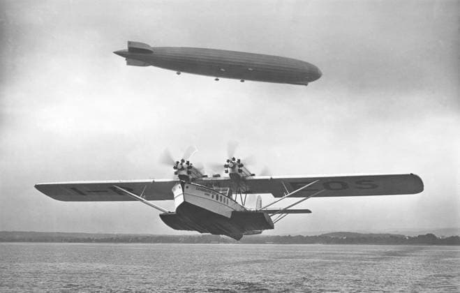 Luftfahrtgeschichte. Luftschiff Graf Zeppelin LZ 127 in der Luft mit dem Amphibienflugzeug Dornier Superwal vor dem Start. 1930s Aviation history. Airship Graf Zeppelin LZ 127 airborn with the amphibian aircraft Dornier Superwal starting in front. 1930s Copyright: imageBROKER Sjoberg ibljsj12899665.jpg