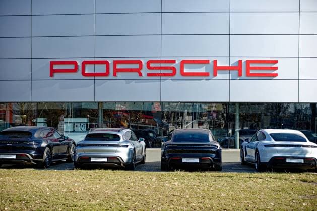 Schriftzug der Automarke Porsche an der Fassade des Porschezentrums in Nürnberg mit davor geparkten Fahrzeugen *** Logo the Car brand Porsche to the Facade of Porsche Center in Nuremberg with before that parked Vehicles 1104401528