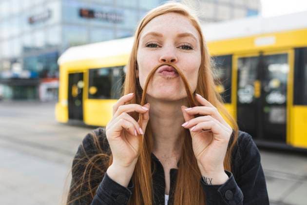 Creative Highlights Symbolfotos Portrait of redheaded young woman making mustache with her hair, Berlin, Germany model released, Symbolfoto, WPEF02001