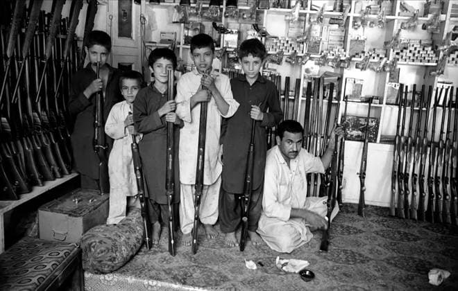 Darra Adamkhel weapons bazaar DARRA ADAMKHEL, PAKISTAN - AUGUST 21: Children and man with rifles posing for photos, at the market weapons in the tribal area of Darra Adamkhel, some 35 kilometres south of Peshawar. Darra Adamkhel is Pakistan s largest weapons bazaar and factory, renowned for its gun making expertise since the late 19th century, Darra is a sprawl of hundreds of workshops where some 3,500 gunsmiths toil on replica weapons, is known to be one of Asia s biggest illicit weapons market on August 21,1986 in Darra Adamkhel, Pakistan. Darra Adamkhel Peshawar Pakistan Copyright: xStefanoxMontesix