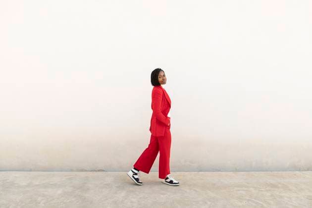 Creative Highlights Symbolfotos Business woman in red suit walking on footpath with hands in pockets model released, Symbolfoto, LMCF02047
