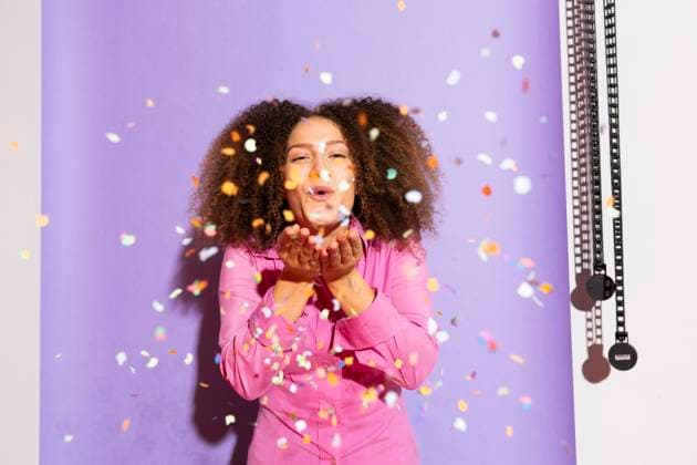 Creative Highlights Symbolfotos Young woman with curly hair in a pink dress laughing and playing with confetti against a purple backdrop model released, Symbolfoto, MIKF00686