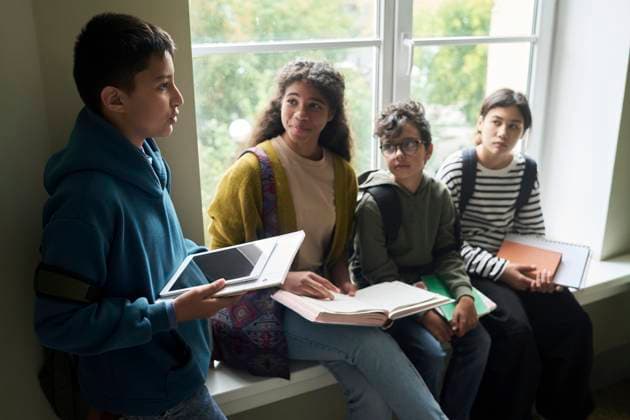 Young students communicating in a school hall with a tablet and notebooks model released, Symbolfoto property released, DSHF02190