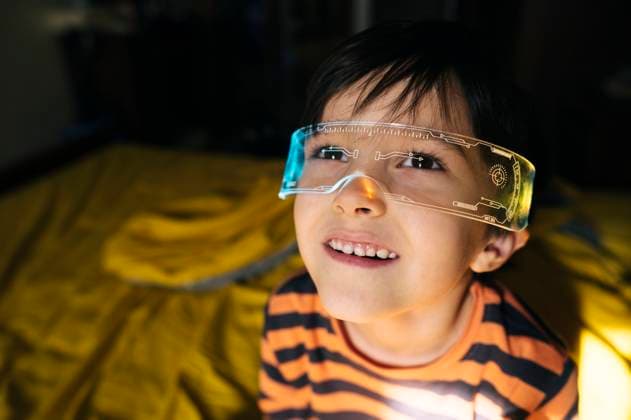 Creative Highlights Symbolfotos Child wearing smart glasses indoors looking curious and smiling model released, Symbolfoto property released, ANAF04529