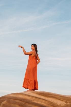 Creative Highlights Symbolfotos Young woman gracefully moving her hands while standing on a rock Portugal, Leiria District, Peniche CR_MGUJ250321-1687888-01 ,model released, Symbolfoto