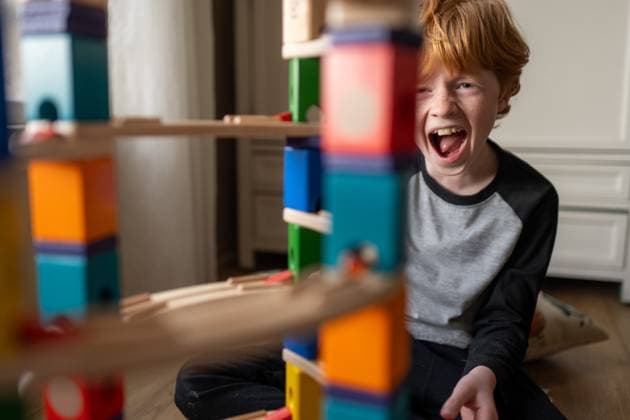 Creative Highlights Symbolfotos Young boy laughing and playing with his block marble run building set Grimes, Iowa, United States CR_LIPF250322-1687455-01 ,model released, Symbolfoto