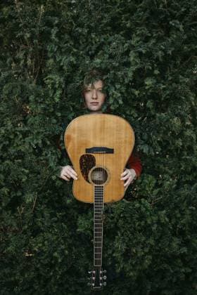 Rothaarige Gitarristin mit Gitarre im grünen Busch Red-haired guitarist with guitar in the green bush Copyright: imageBROKER MichaelaxBegsteiger ibxbeg12924491.jpg ,model released, Symbolfoto ,property released