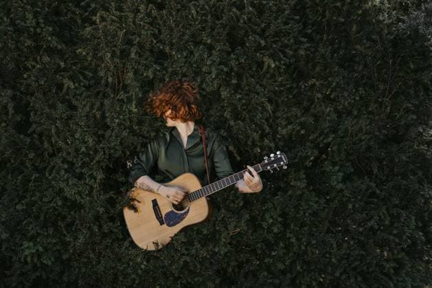Rothaarige Gitarristin mit Gitarre im grünen Busch Red-haired guitarist with guitar in the green bush Copyright: imageBROKER MichaelaxBegsteiger ibxbeg12924494.jpg ,model released, Symbolfoto ,property released