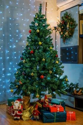 Figurines of Santa and gnomes stand on colorful gifts lying under the Christmas tree in the room. High quality photo , 56057176.jpg, holidays, arrangement, figurines, santa, gnomes, stand, colorful, gifts, lying, under, christmas, tree, room, elves, red, golden, balls, luminous, garlands, new year, wreath, festive, design, home, close up RECORD DATE NOT STATED