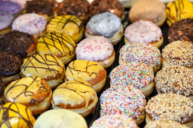 Bunt verzierte Berliner (Krapfen) zur Faschingszeit in den Auslagen der Bäckerei In der Bäckerei sind bunt verzierte Berliner (Krapfen) ausgestellt. Gebäck aus süßem Hefeteig für die Karnevalszeit (Faschingskrapfen) Copyright: xZoonar.com SandraAlkadox 23008533