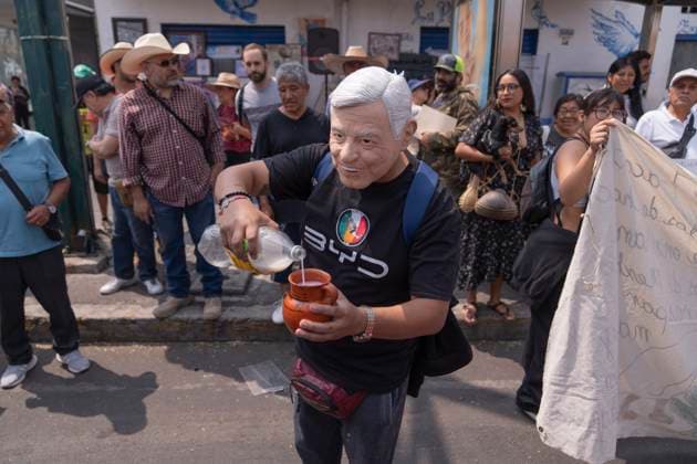 News Bilder des Tages March 25, 2025, Mexico, Mexico: A demonstrator disguised as a former Mexico President AMLO, serves pulque in a jug during a protest against the closure of the Paloma Azul pulqueria. Pulque workers held a protest to demand that the Administrative Verification Institute (INVEA) stop the closure of pulquerias in Mexico City, such as Paloma Azul. This year, up to 15 pulquer™as have been closed. Mexico Mexico - ZUMAs197 20250325_aaa_s197_116 Copyright: xGuillermoxDiazx